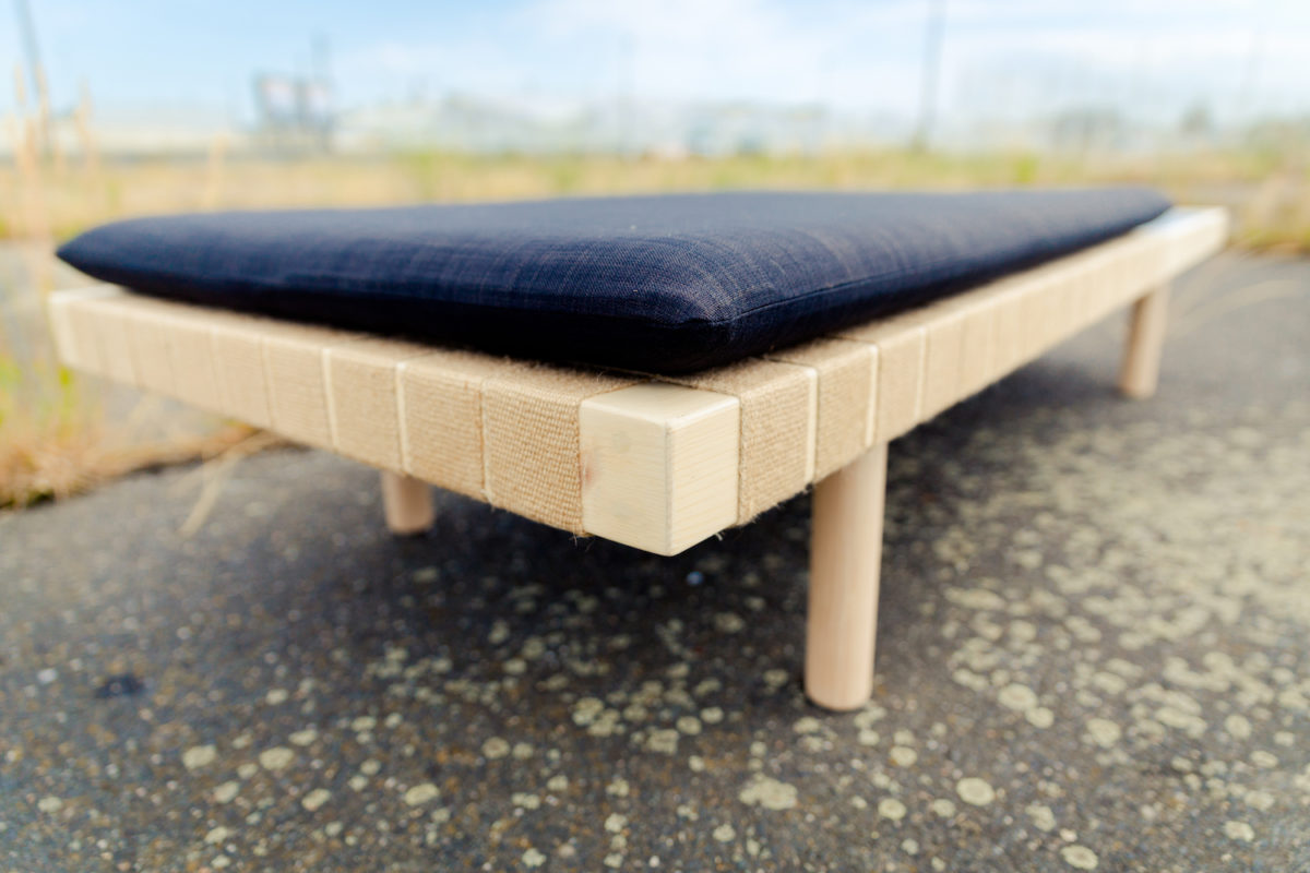 banquette en bois et sangle de jute avec un plateau noir et un matelas création de l'agence Parade