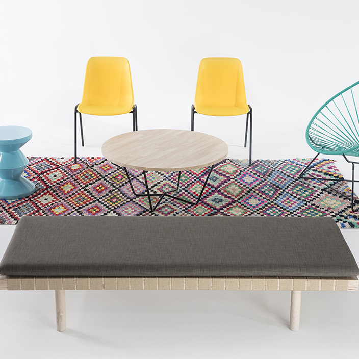 pack salon tapis boucherouite multicolore, banquette en bois et sangles de jute et matelas gris, table basse en bois, chaises en plastique jaune, fauteuil Acapulco Boqa turquoise et tabouret zigzag turquoise Pols Potten, agence Parade