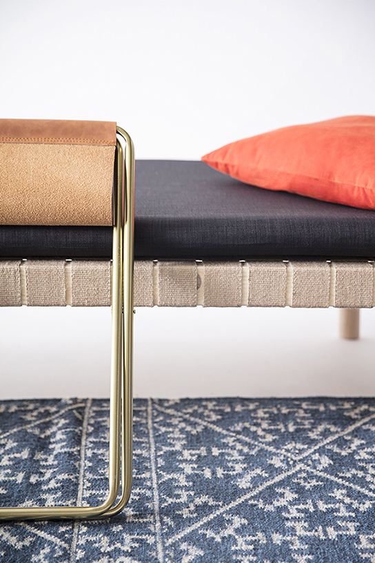 tapis kilim bleu, banquette en bois et sangles jute, matelas en tissu gris, oreiller orange, tabouret en métal doré et assise cuir, agence Parade